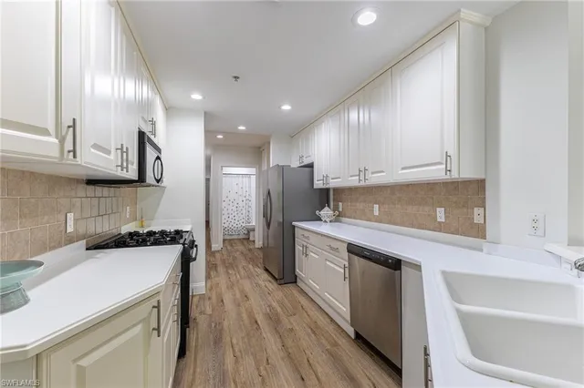 a kitchen with a sink a stove and cabinets