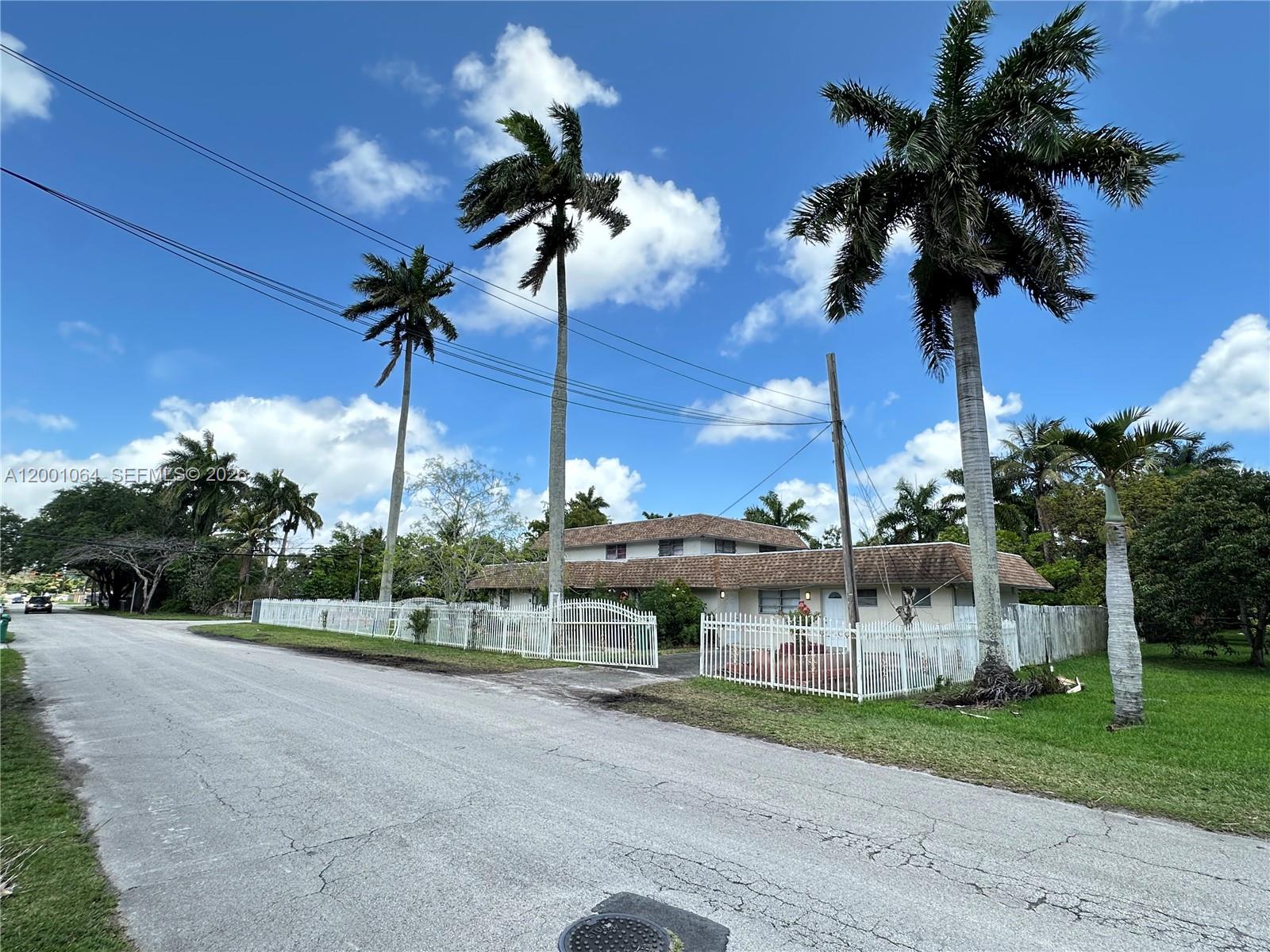 200 Northeast 158th Street Miami, FL 33162 - Photo 7 of 16 a view of a house with a yard and palm trees