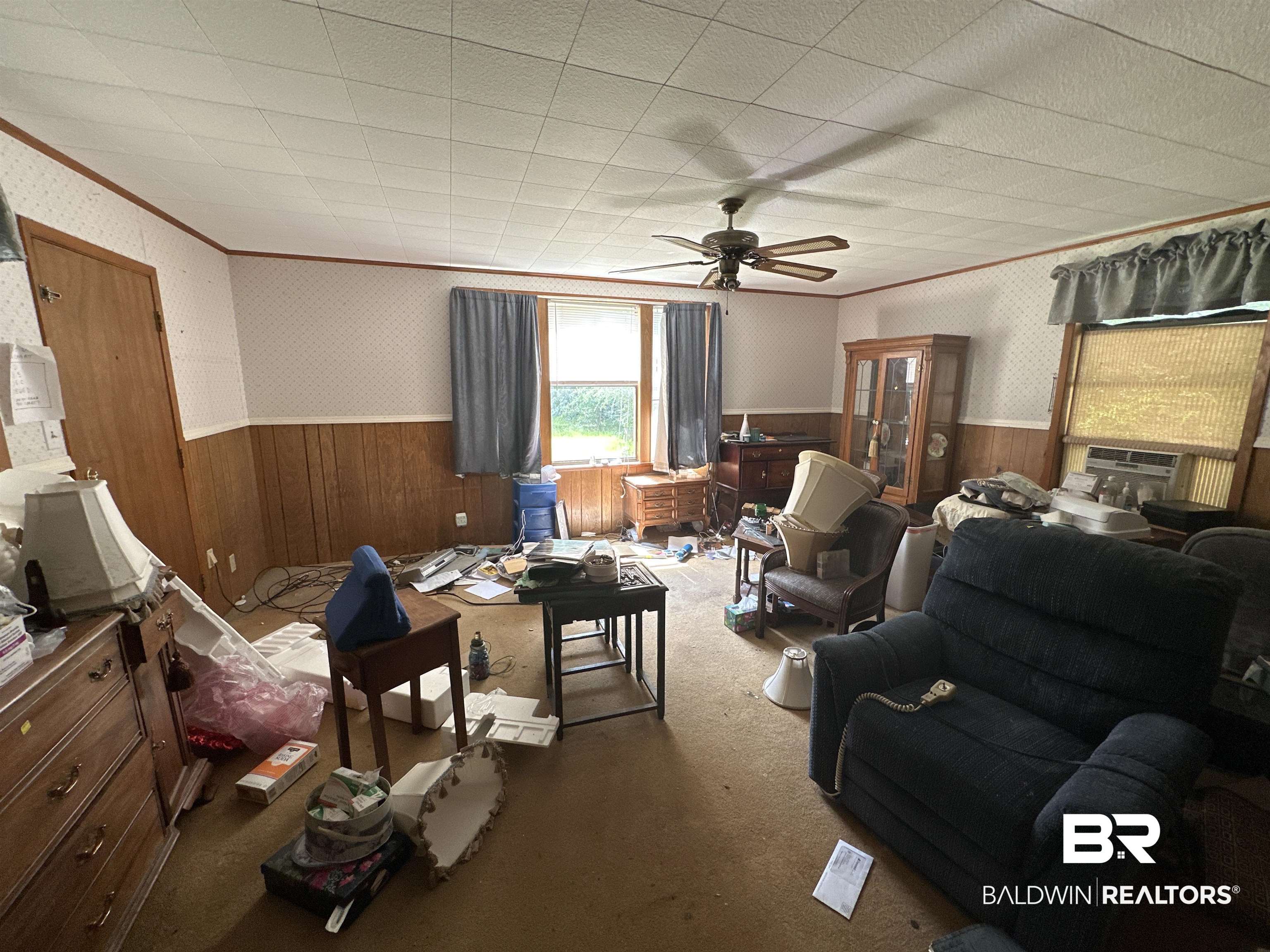 1850 Repoll Drive Mobile, AL 36695 - Photo 6 of 26 Carpeted living room with wood walls, ceiling fan, and crown molding