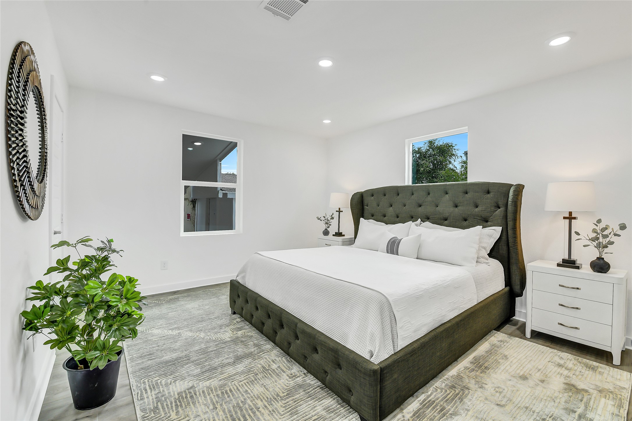110 Harris Court Houston, TX 77009 - Photo 17 of 31 a bedroom with a large bed and a potted plant