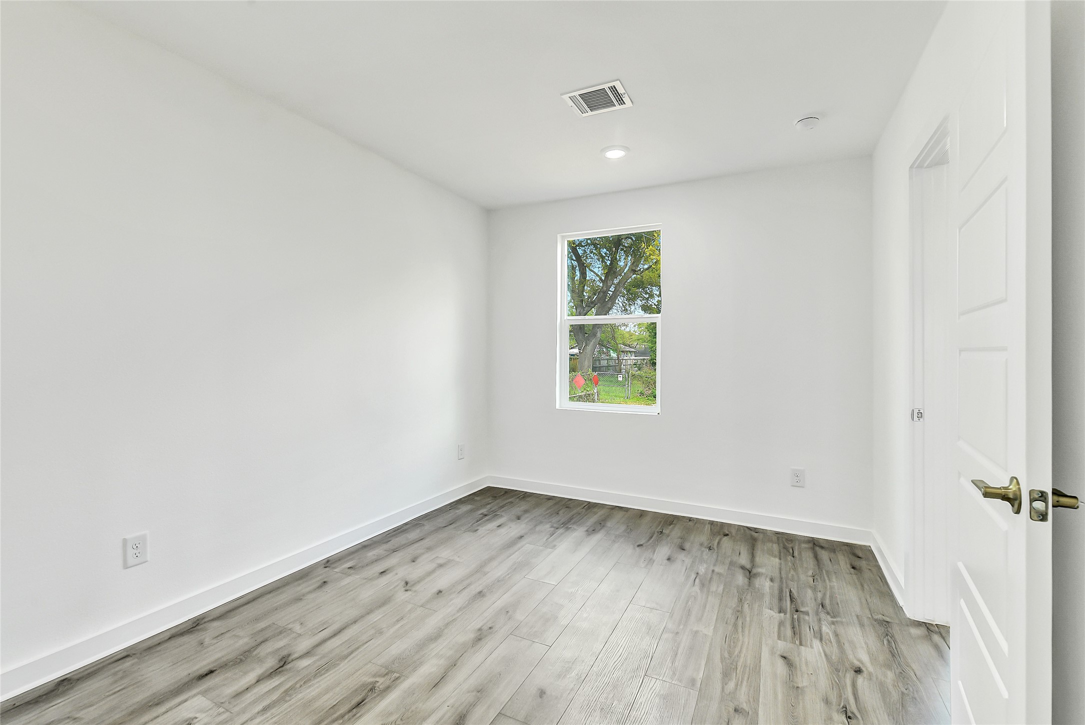 110 Harris Court Houston, TX 77009 - Photo 24 of 31 an empty room with wooden floor and windows