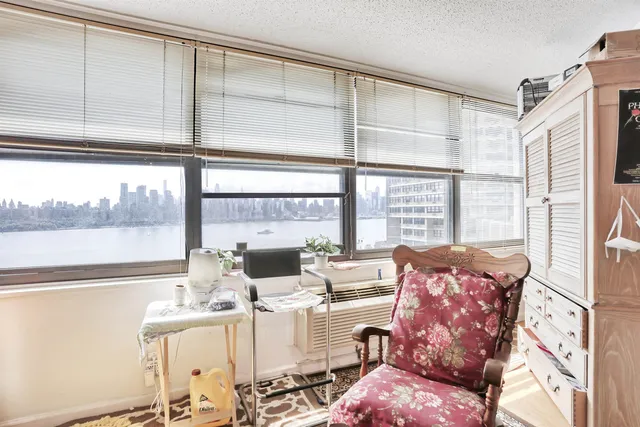 a bedroom with furniture and a large window