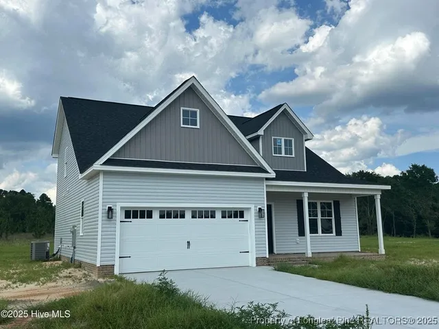 a view of house with yard and a large tree in it