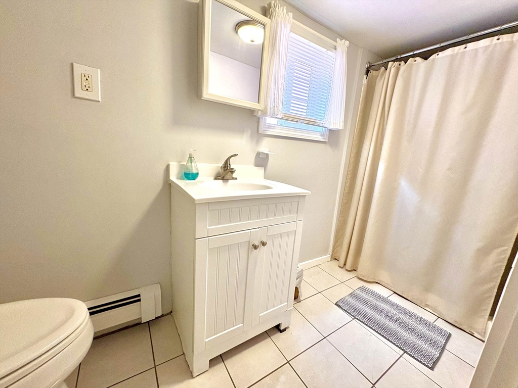 285 Roxbury Street Boston, MA 02119 - Photo 6 of 15 a bathroom with a sink a toilet and tub