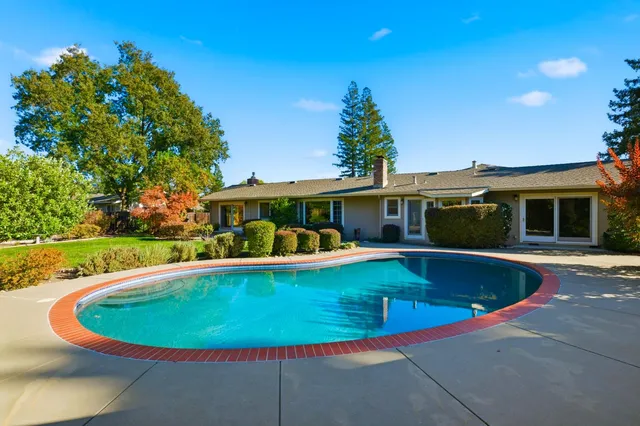 a view of a house with swimming pool and sitting area