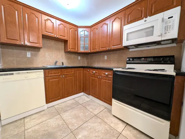a kitchen with stainless steel appliances granite countertop a stove microwave and cabinets