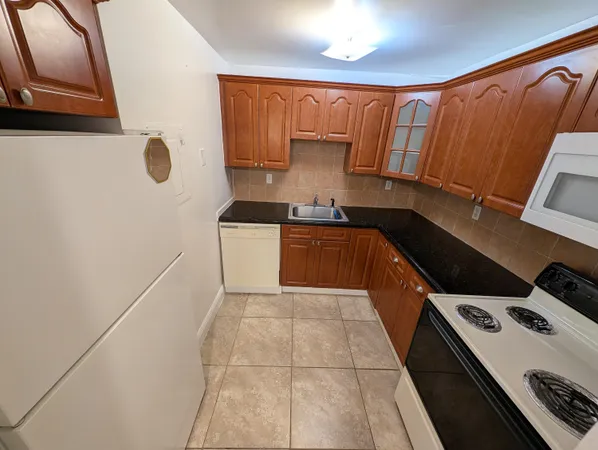 a kitchen with a sink a stove top oven and cabinetry