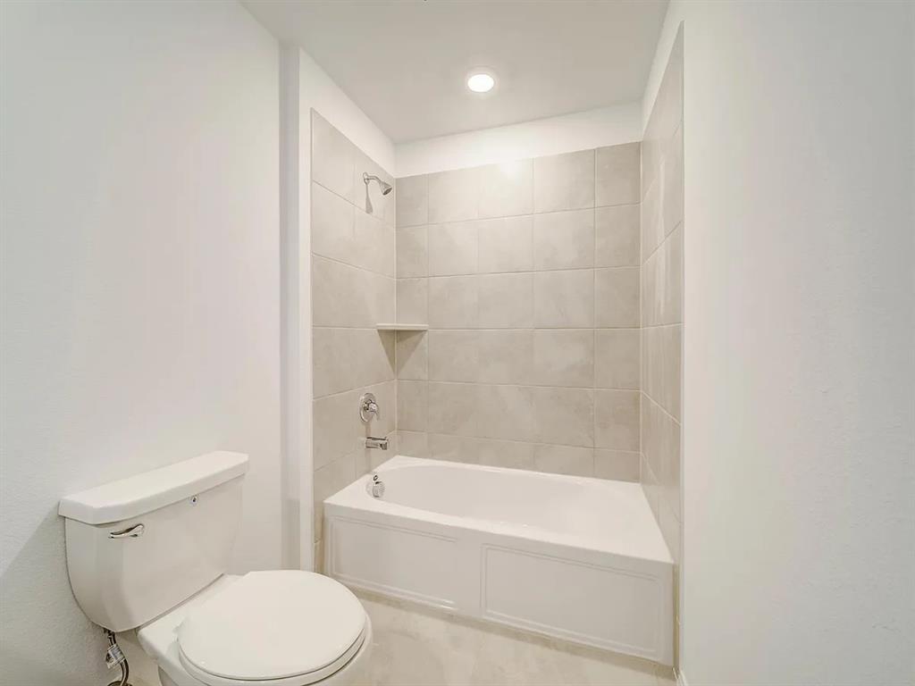 352 Sun Bluff Road Fort Worth, TX 76052 - Photo 30 of 33 Full bathtub with a tiled surround, integrated shower, and built-in corner shelf