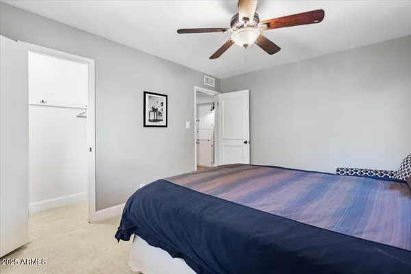 a bedroom with a large bed chandelier and a window