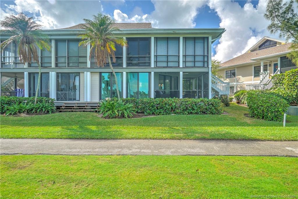 319 Golfview Circle, Unit 319 Stuart, FL 34996 - Photo 11 of 56 a front view of a house with a yard and potted plants
