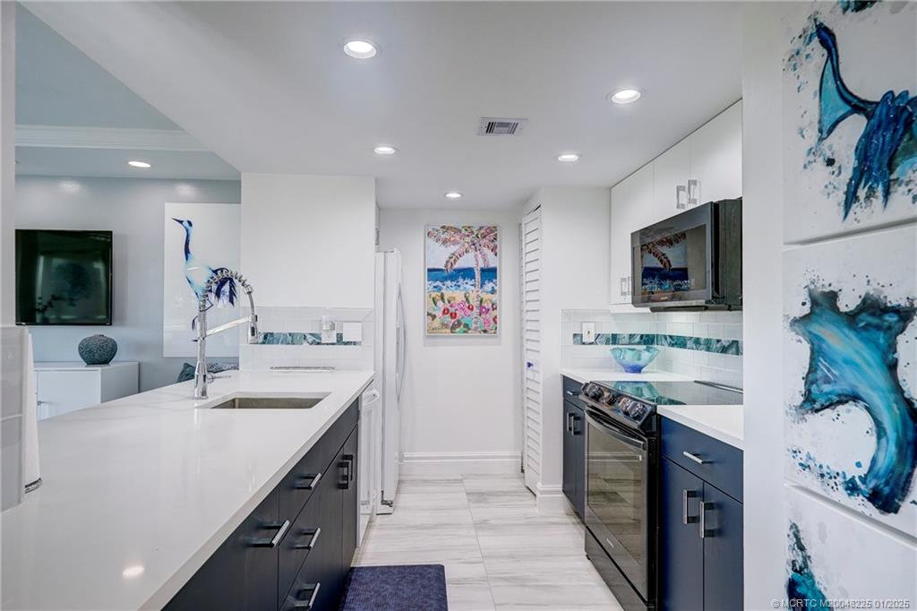 319 Golfview Circle, Unit 319 Stuart, FL 34996 - Photo 32 of 56 a kitchen with a sink stove and refrigerator