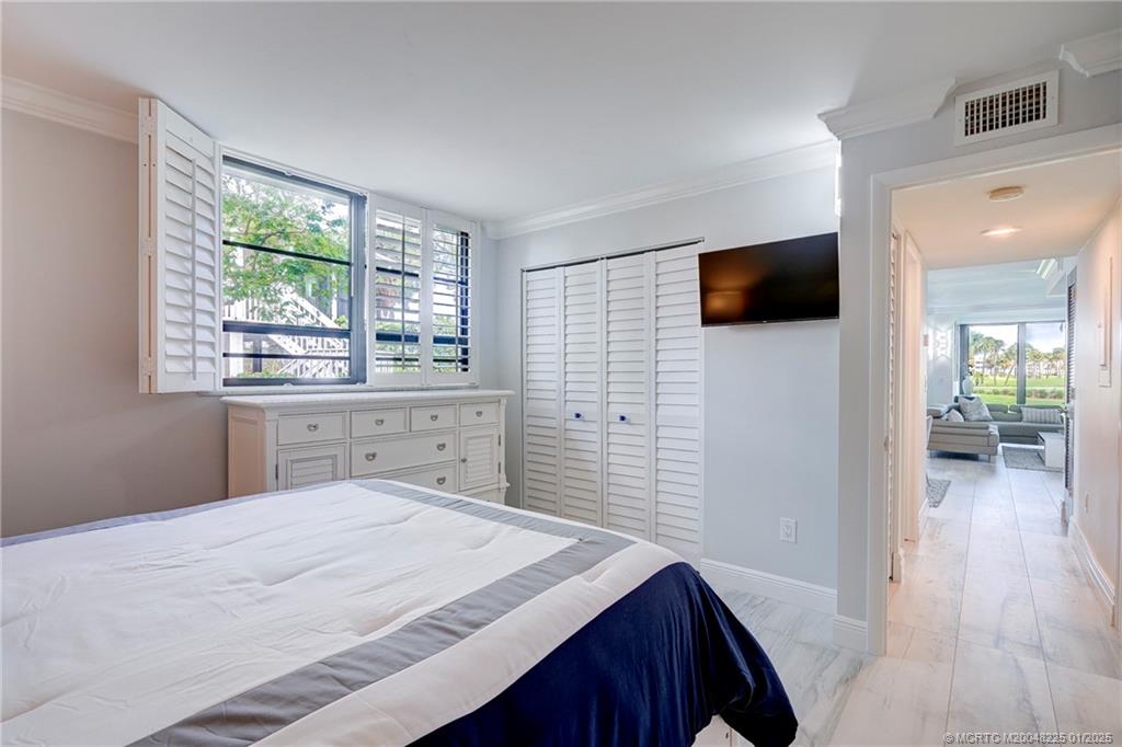319 Golfview Circle, Unit 319 Stuart, FL 34996 - Photo 39 of 56 a bedroom with a bed and a flat screen tv
