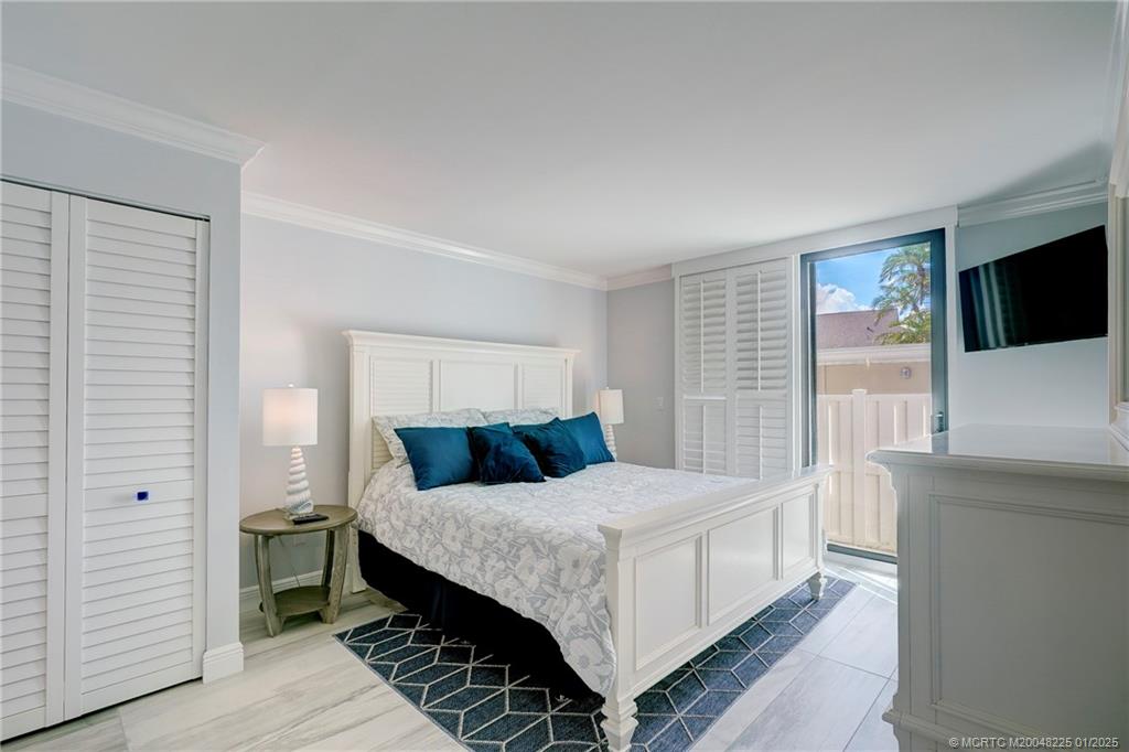 319 Golfview Circle, Unit 319 Stuart, FL 34996 - Photo 41 of 56 a bedroom with a bed and a flat screen tv