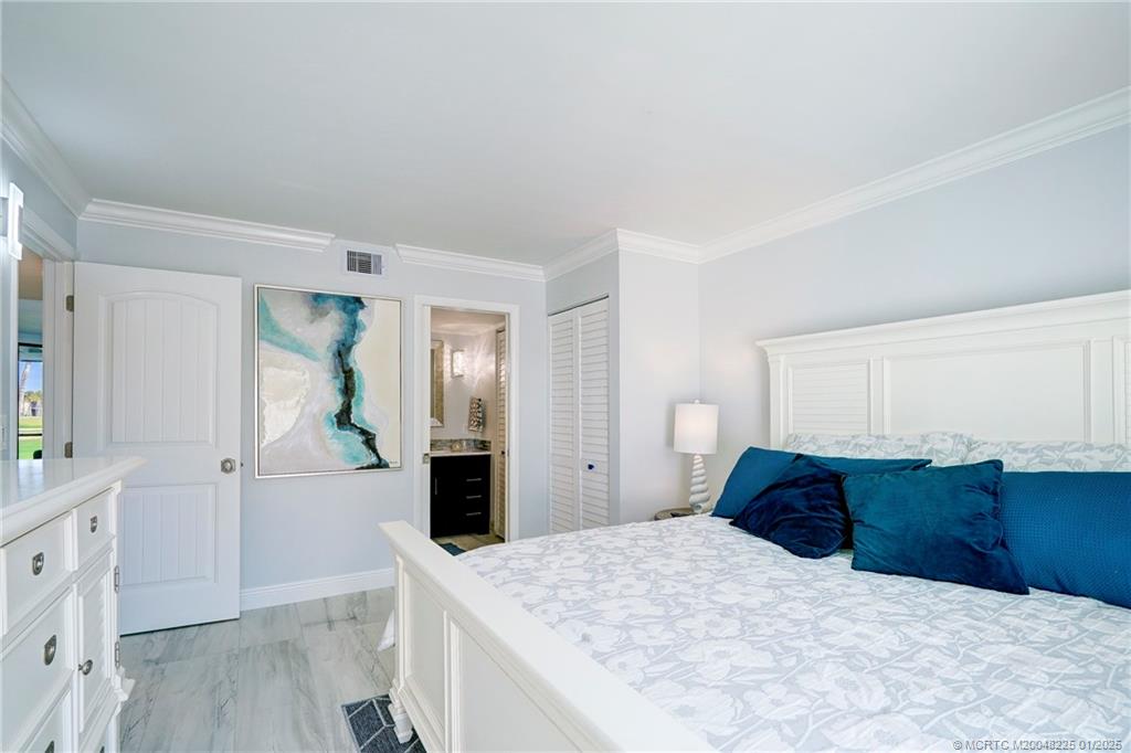 319 Golfview Circle, Unit 319 Stuart, FL 34996 - Photo 43 of 56 a bedroom with a bed and a dresser