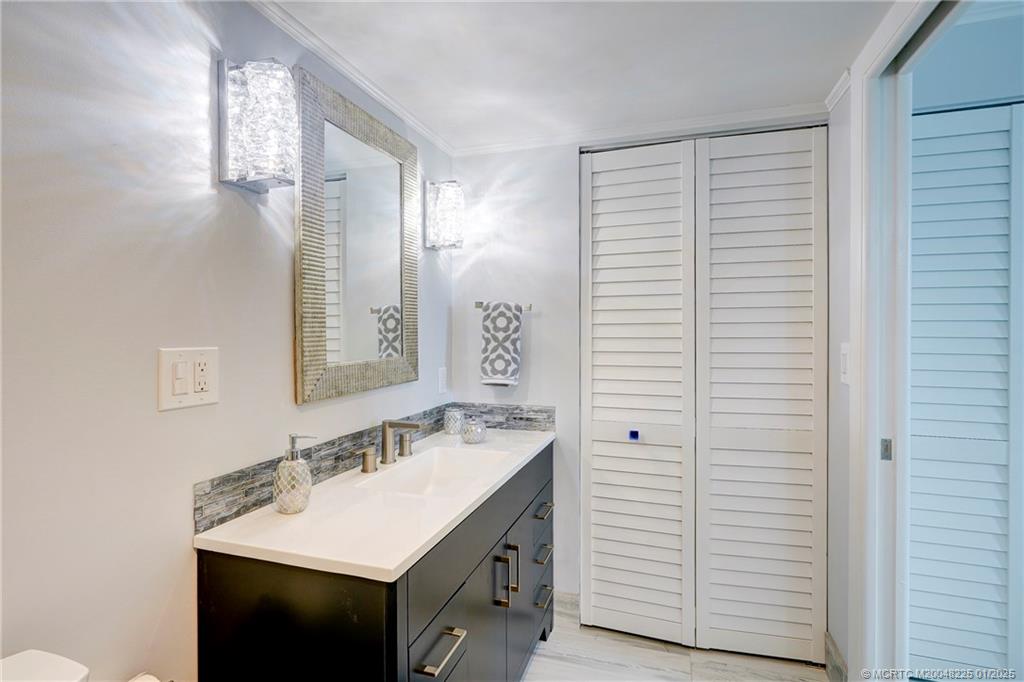 319 Golfview Circle, Unit 319 Stuart, FL 34996 - Photo 46 of 56 a bathroom with a sink a mirror and a shower