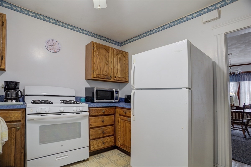 44 Cottage Park Road Winthrop, MA 02152 - Photo 15 of 39 a kitchen with appliances a refrigerator a stove a microwave and cabinets