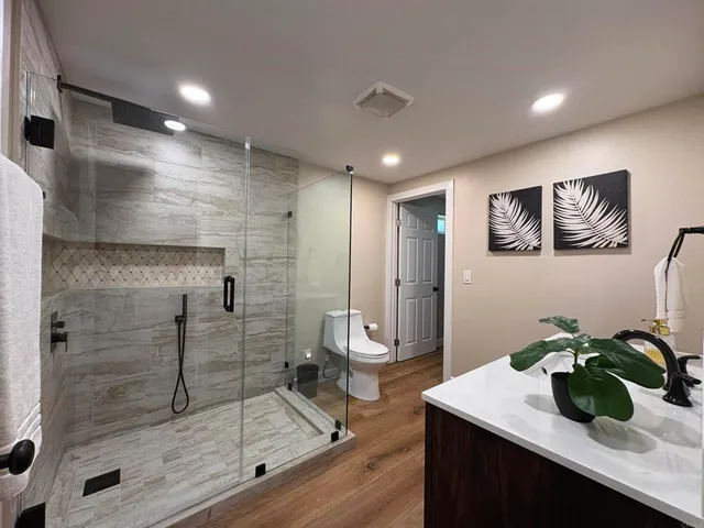 a bathroom with a granite countertop sink a mirror and shower
