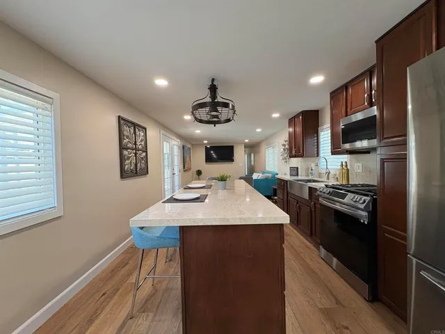 a large kitchen with stainless steel appliances kitchen island a stove and a sink