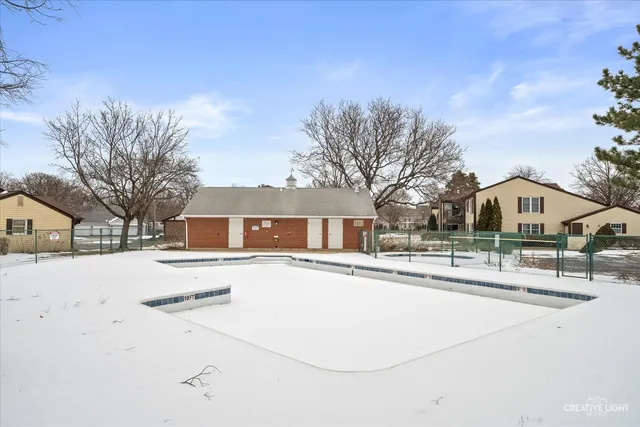 a view of a white house with a yard covered in snow