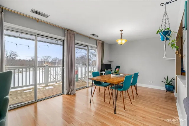a dining room with furniture a chandelier and wooden floor