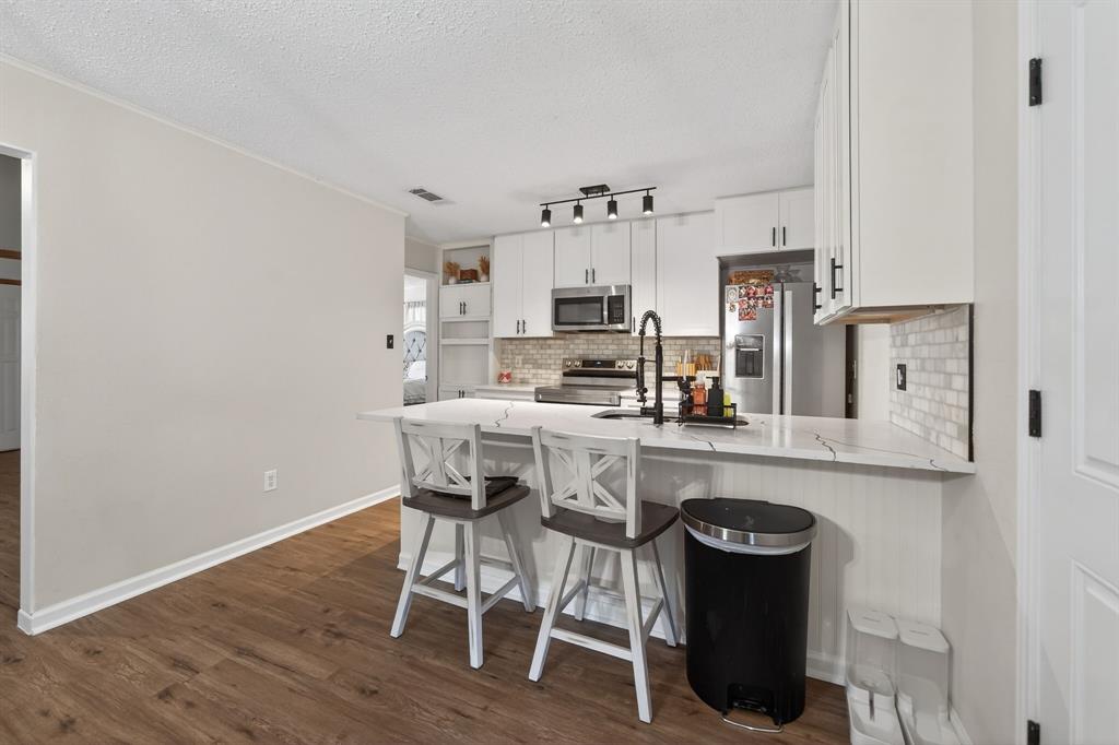 11474 Farm To Market 3094 Scurry, TX 75158 - Photo 11 of 40 a kitchen with stainless steel appliances a white table chairs and a refrigerator