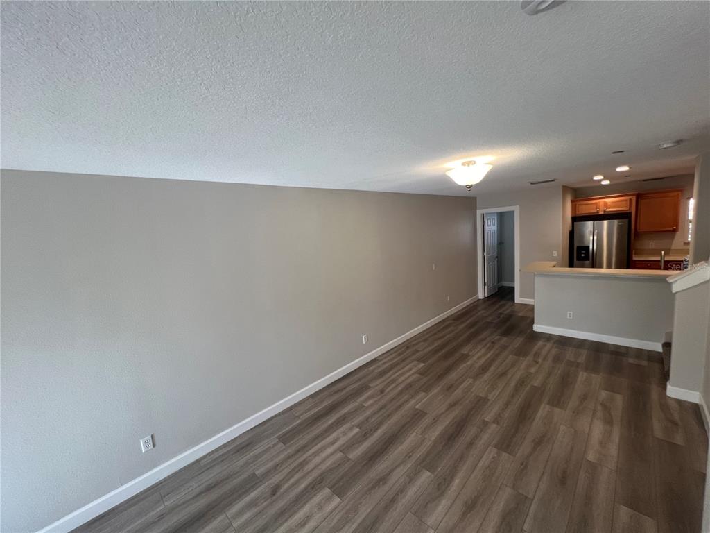 7350 Black Walnut Way Lakewood Ranch, FL 34202 - Photo 20 of 52 a view of a room with wooden floor and kitchen