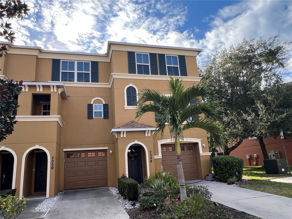 7350 Black Walnut Way Lakewood Ranch, FL 34202 - Photo 3 of 52 a front view of a house with a garden