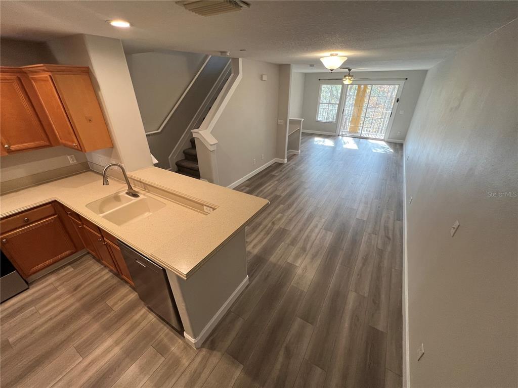 7350 Black Walnut Way Lakewood Ranch, FL 34202 - Photo 5 of 52 a hallway view with wooden floor and staircase