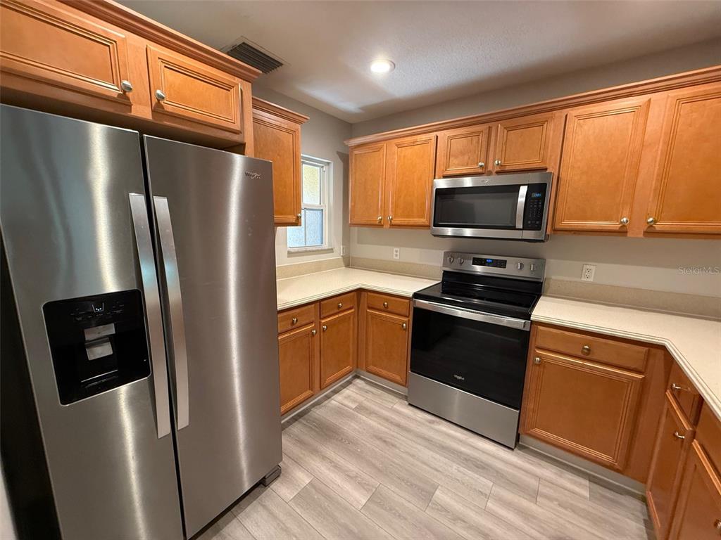 7350 Black Walnut Way Lakewood Ranch, FL 34202 - Photo 6 of 52 a kitchen with stainless steel appliances a refrigerator stove and microwave