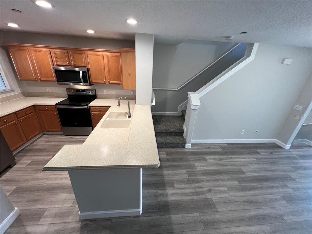 7350 Black Walnut Way Lakewood Ranch, FL 34202 - Photo 7 of 52 a large white kitchen with wooden floor
