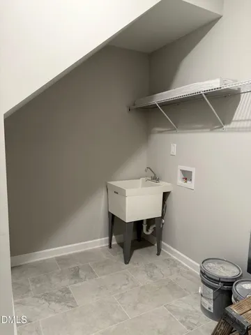 a view of a storage and utility room with two washing machine