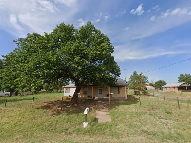 a backyard of a house with table and chairs