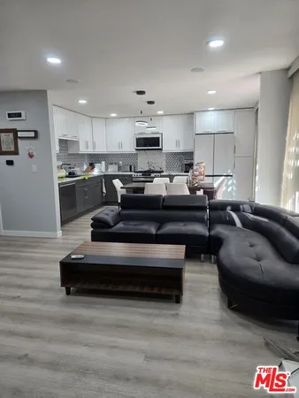 a living room with furniture and kitchen view