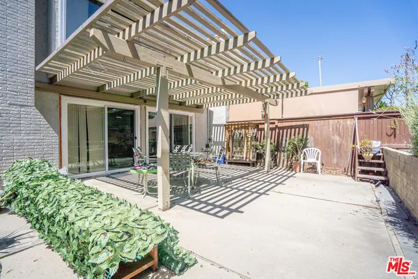 a view of a patio with a table and chairs and potted plants