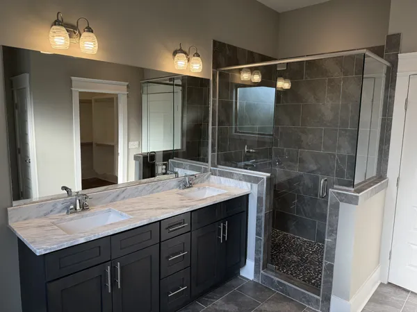 a bathroom with a shower sink vanity and mirror