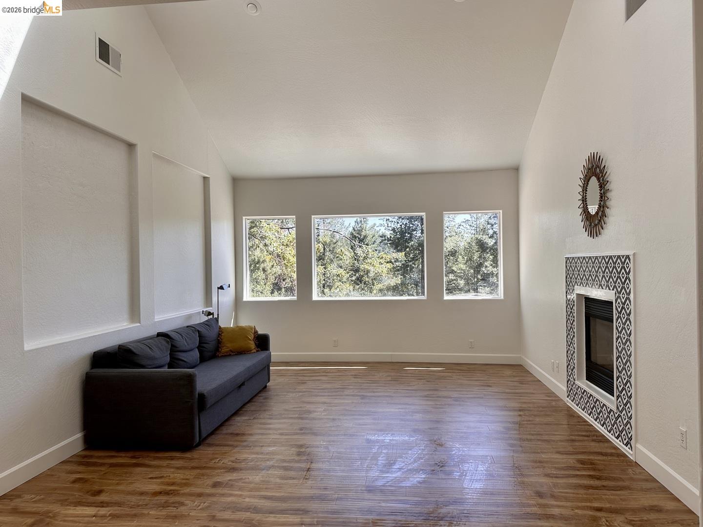 2080 Nelson Road Camino, CA 95709 - Photo 22 of 55 Wood-finish flooring, vaulted ceiling, recessed lighting, gas fireplace with decorative tile surround, and multiple windows