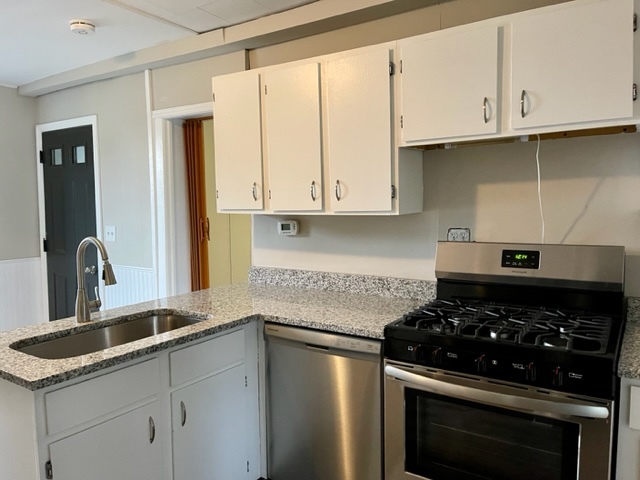 238 Lucas Street Sycamore, IL 60178 - Photo 7 of 28 a kitchen with granite countertop a stove and a sink
