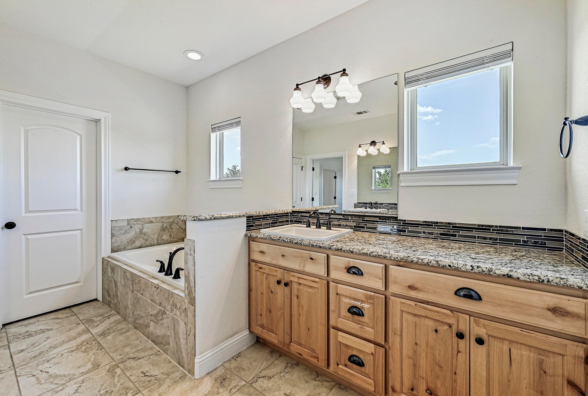 312 First Down Dash Burnet, TX 78611 - Photo 19 of 39 a spacious bathroom with a granite countertop tub sink and mirror