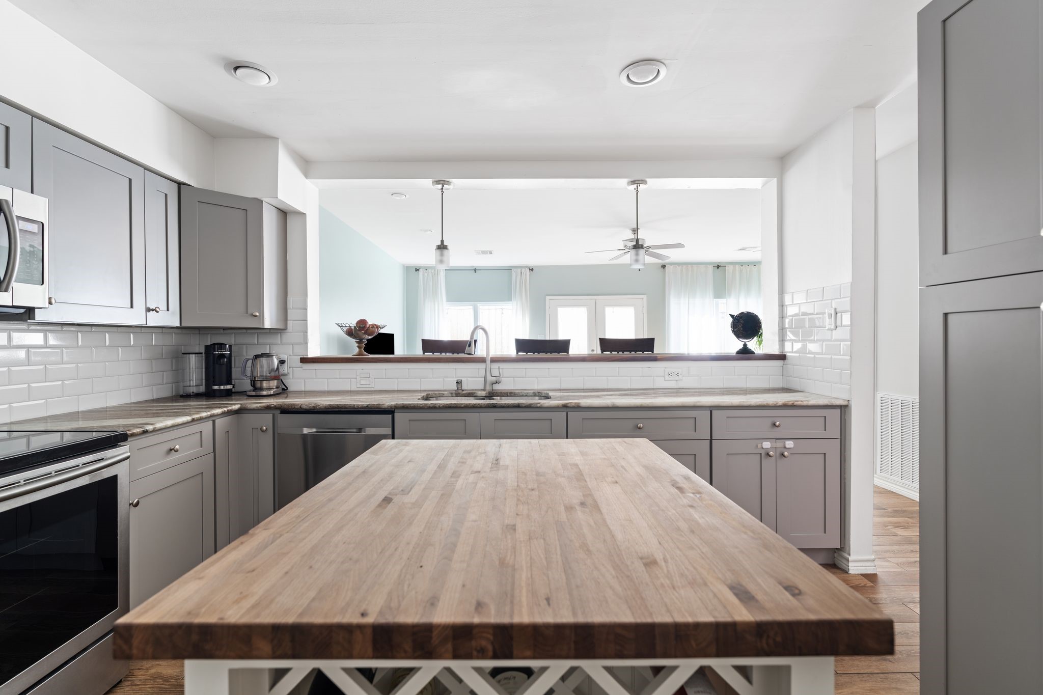 2612 Yupon Street Houston, TX 77006 - Photo 13 of 40 Bar height counter seating connects the kitchen and living area, creating a natural gathering space ideal for entertaining and casual dining.