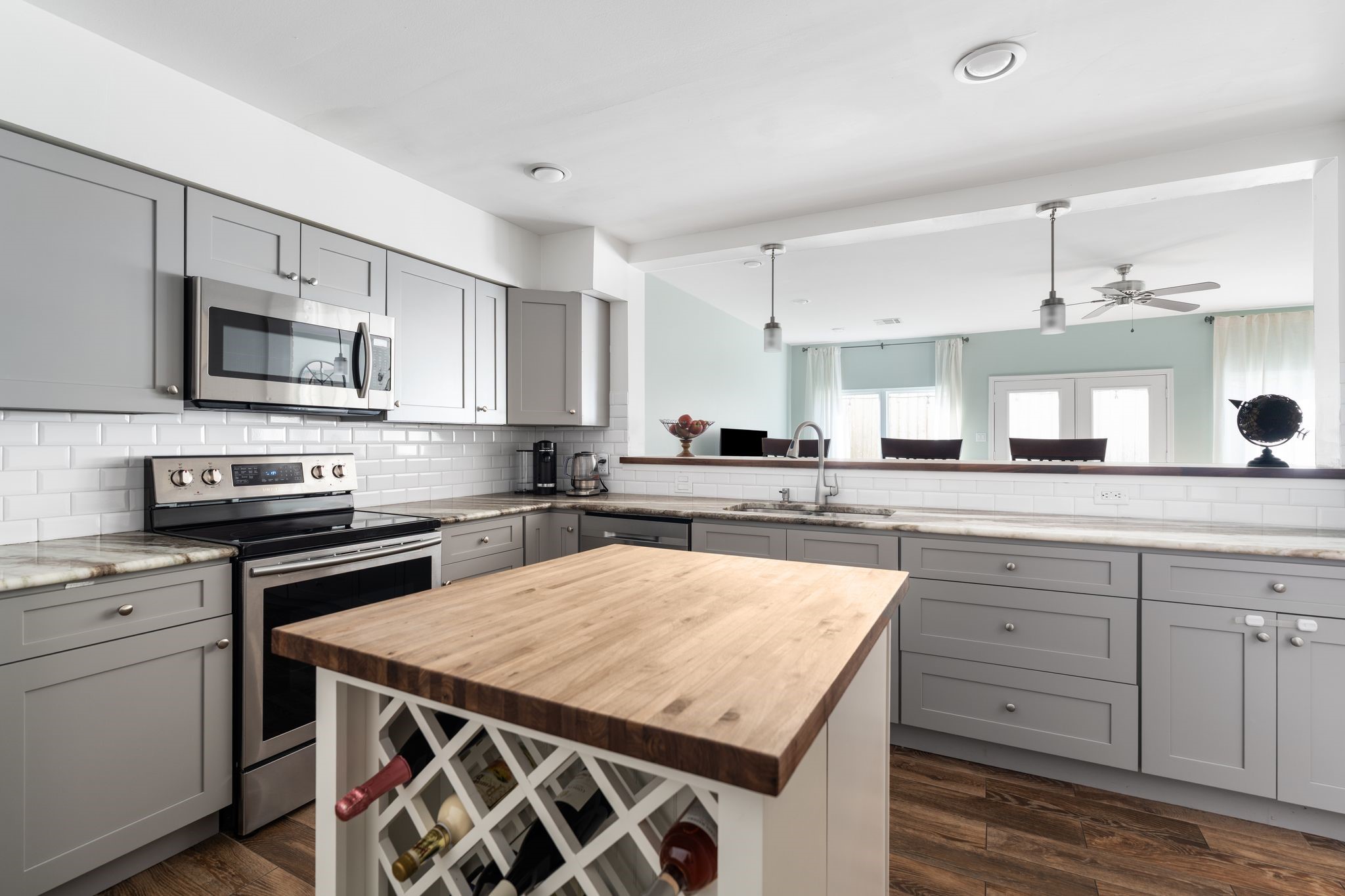 2612 Yupon Street Houston, TX 77006 - Photo 4 of 40 Open sightlines from the kitchen to the living room highlight the electric range, stainless steel appliances, wine storage, and generous drawer space for cookware and everyday essentials.