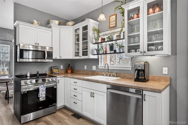 a kitchen with stainless steel appliances granite countertop a sink stove and cabinets