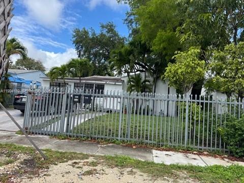 97 Northwest 69th Street Miami, FL 33150 - Photo 2 of 3 a view of a house with a small yard and a large tree