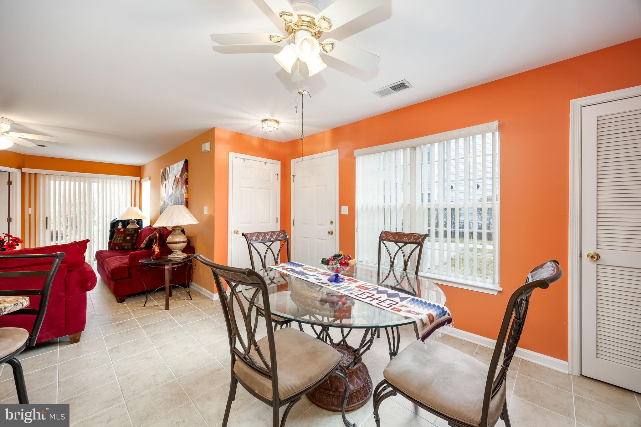 11427 Manklin Creek Road, Unit 7 Ocean Pines, MD 21811 - Photo 14 of 42 a view of a dining room with furniture large windows and wooden chandelier