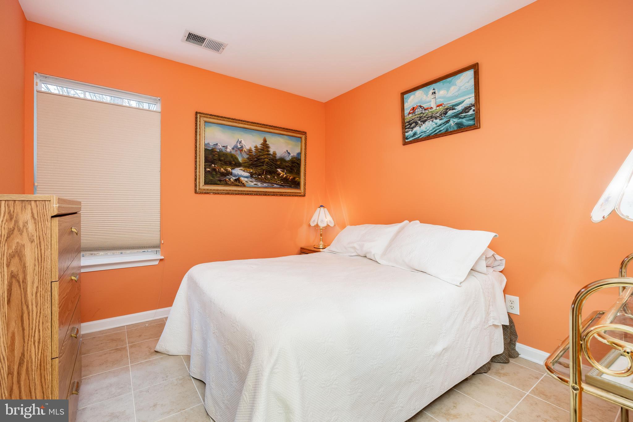 11427 Manklin Creek Road, Unit 7 Ocean Pines, MD 21811 - Photo 25 of 42 a bedroom with a bed and a painting on the wall