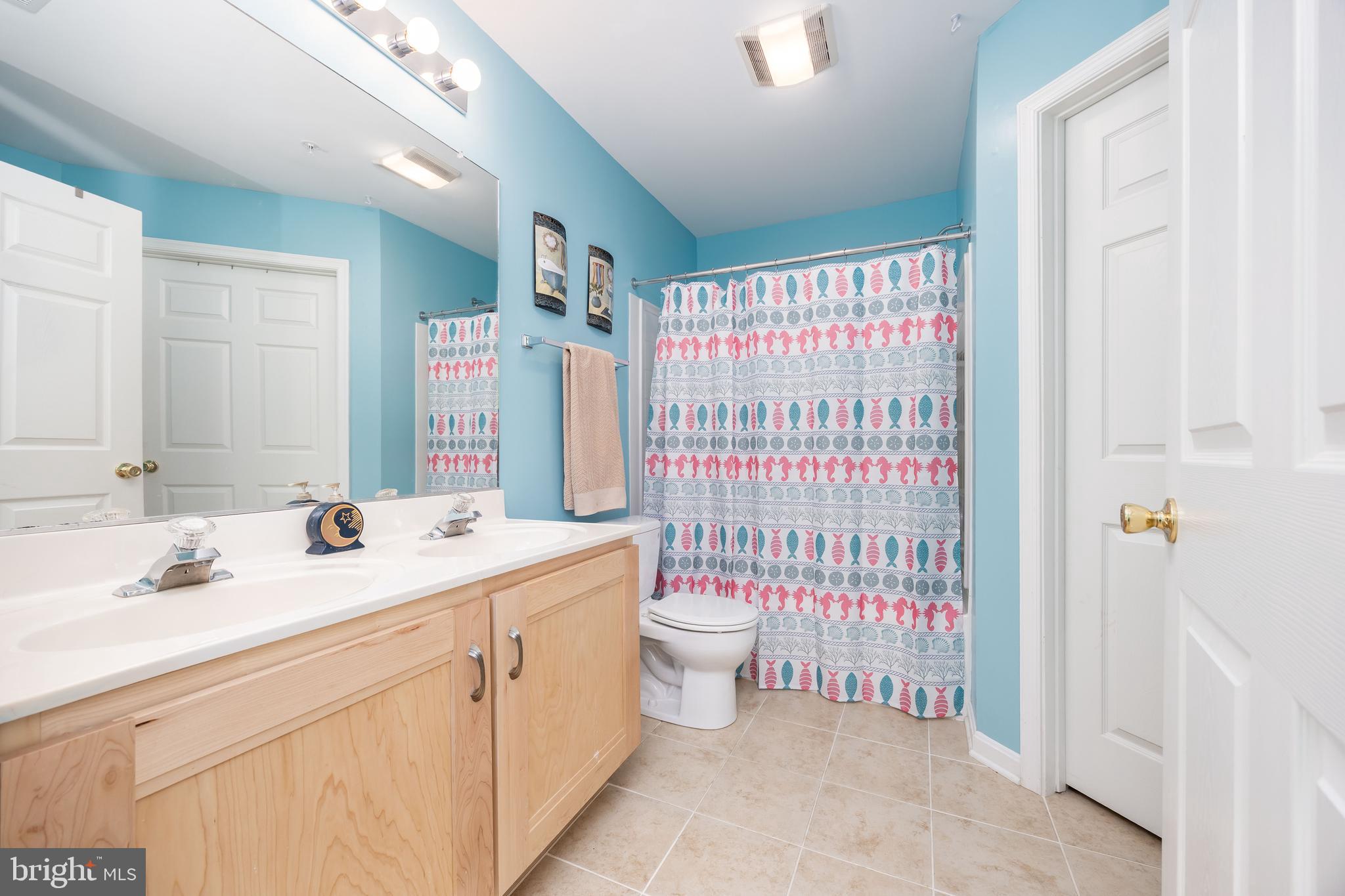 11427 Manklin Creek Road, Unit 7 Ocean Pines, MD 21811 - Photo 32 of 42 a bathroom with a sink a toilet and shower curtain
