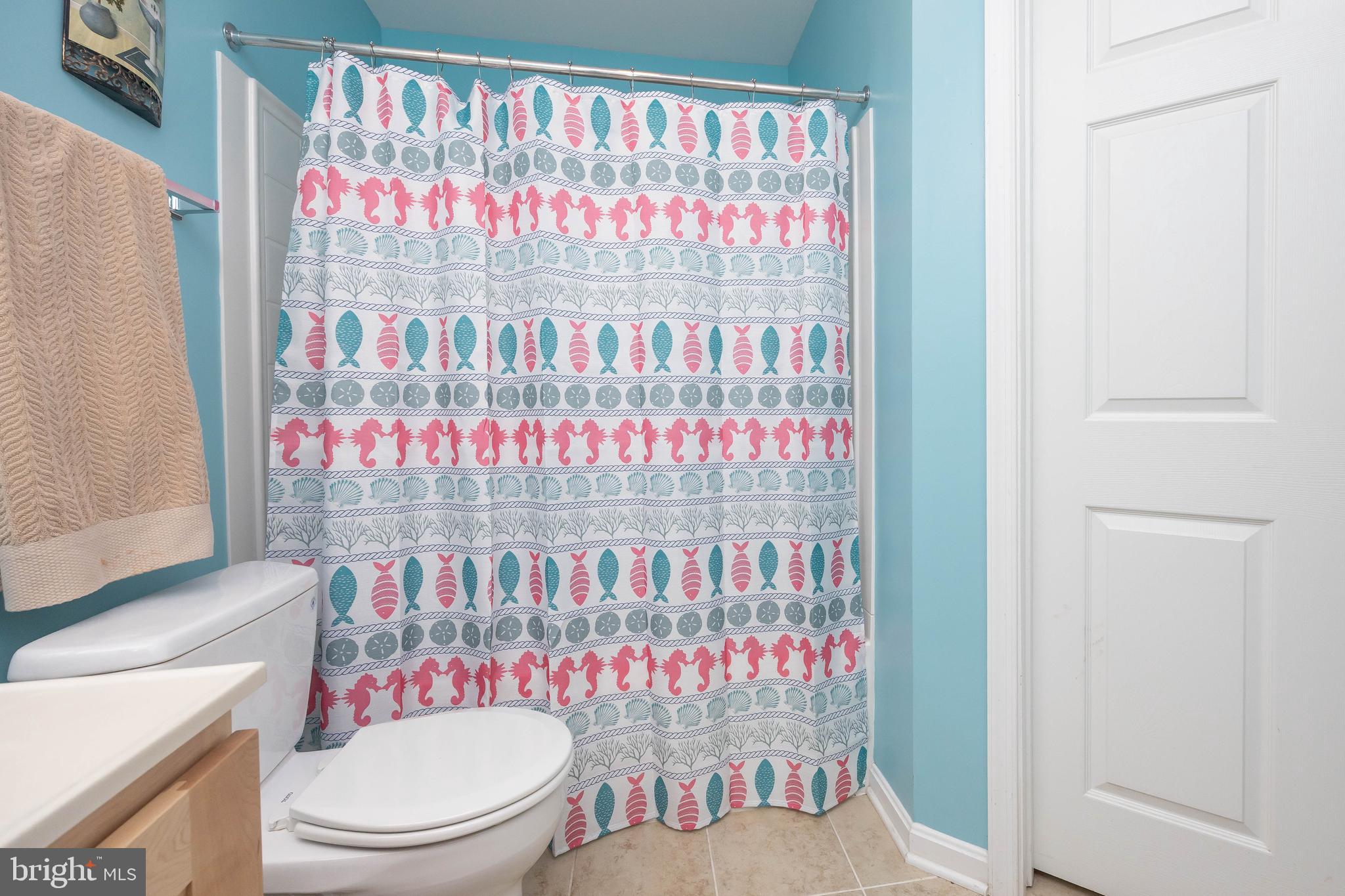 11427 Manklin Creek Road, Unit 7 Ocean Pines, MD 21811 - Photo 33 of 42 a bathroom with a sink a toilet and a shower curtain