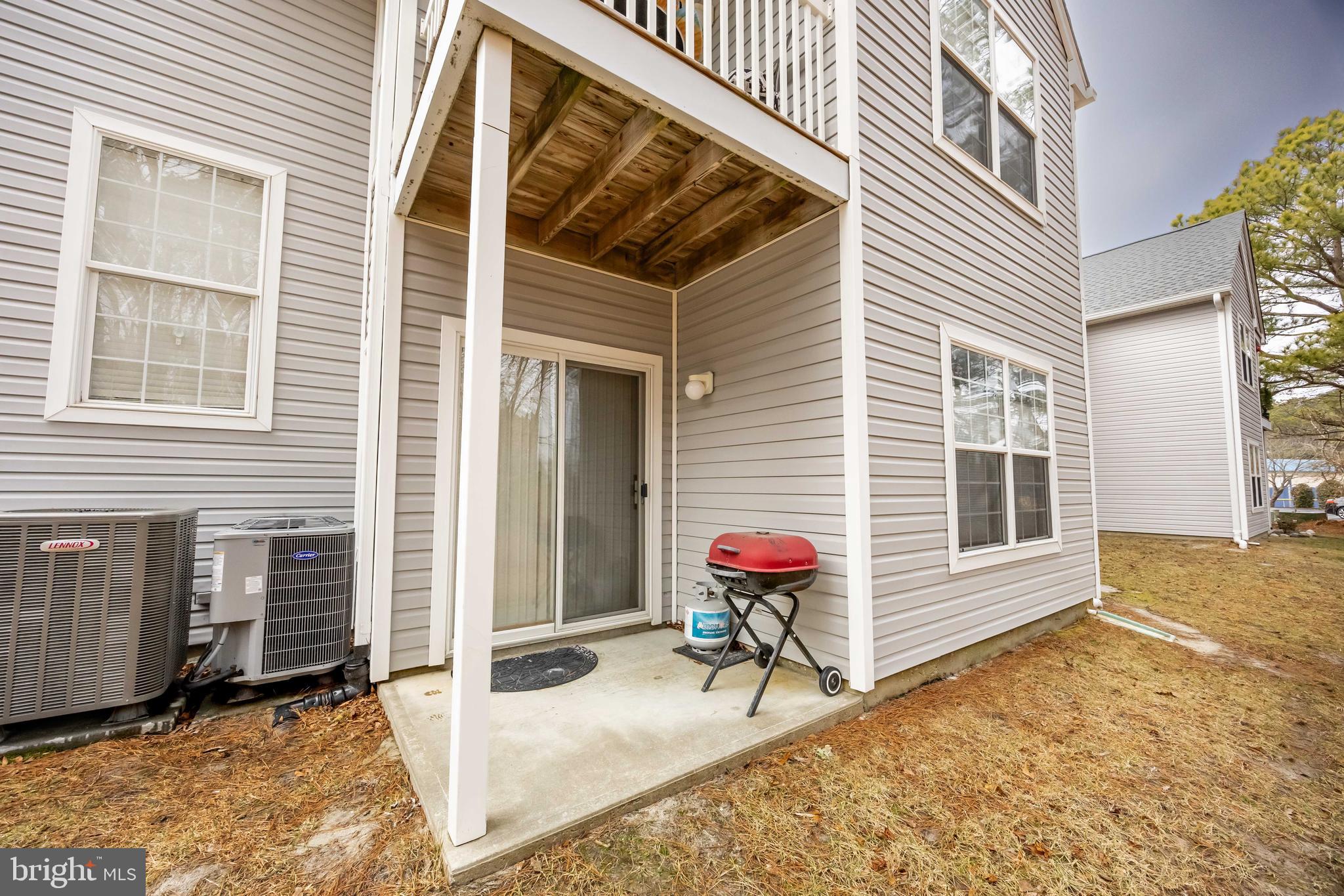11427 Manklin Creek Road, Unit 7 Ocean Pines, MD 21811 - Photo 40 of 42 a view of a porch with a table and chairs and door