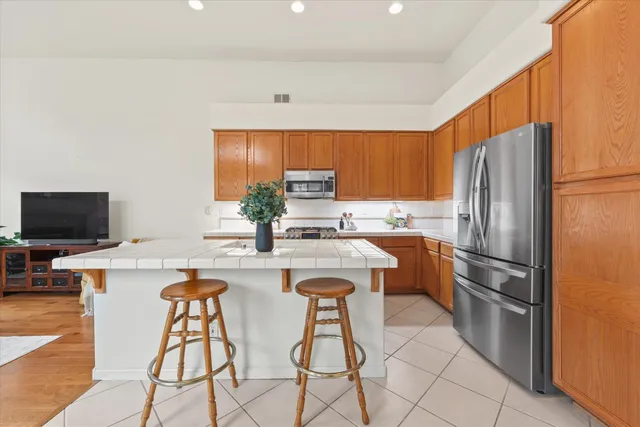 a kitchen with stainless steel appliances a refrigerator a stove a sink and a refrigerator