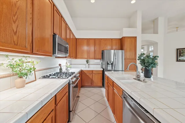 a kitchen with stainless steel appliances granite countertop a sink a stove and a refrigerator