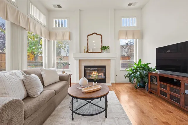 a living room with furniture a fireplace and a large window
